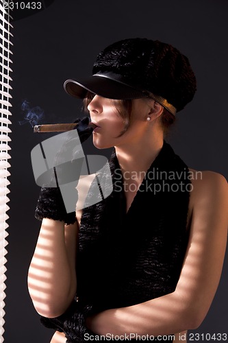 Image of woman in black astrakhan smoking cigar