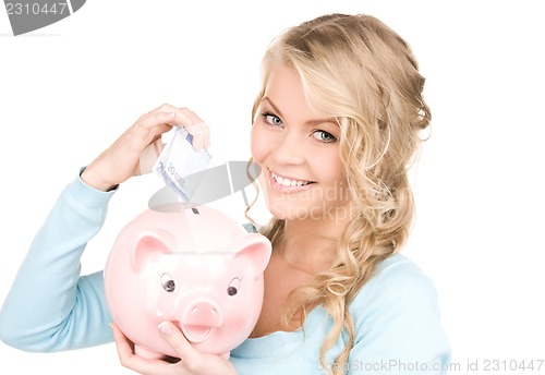 Image of lovely woman with piggy bank and money