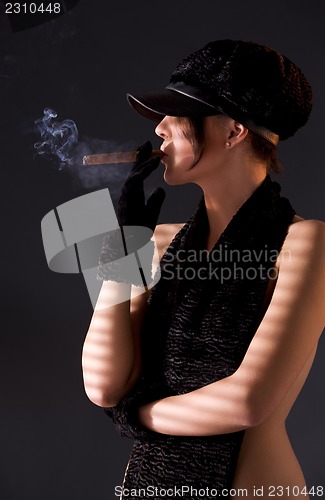 Image of woman in black astrakhan smoking cigar