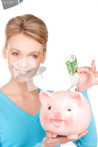 Image of lovely woman with piggy bank and money
