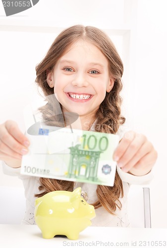 Image of little girl with piggy bank and money