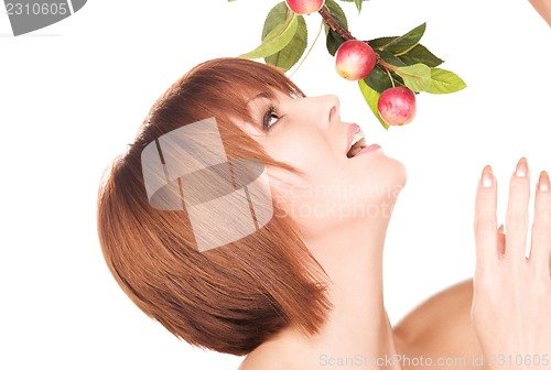 Image of happy woman with apple twig