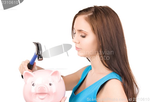 Image of teenage girl with piggy bank and hammer