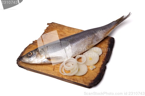 Image of Herring with onion rings on old wooden cutting board