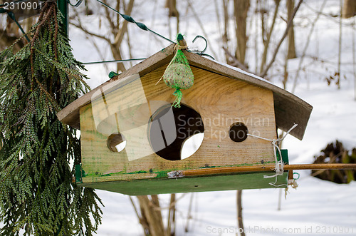 Image of wooden bird feeder with three holes 