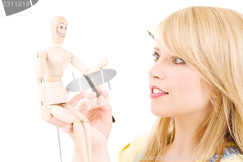 Image of happy teenage girl with wooden model dummy