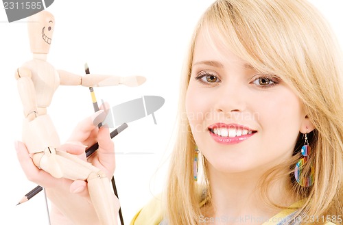 Image of happy teenage girl with wooden model dummy