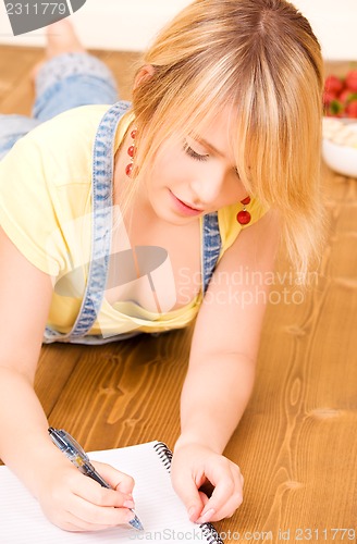 Image of teenage girl with notebook and pen