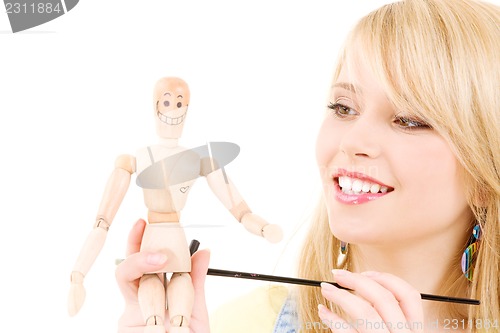 Image of happy teenage girl with wooden model dummy