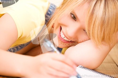 Image of teenage girl with notebook and pen