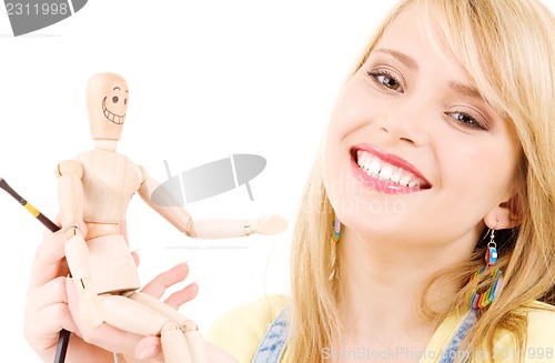 Image of happy teenage girl with wooden model dummy