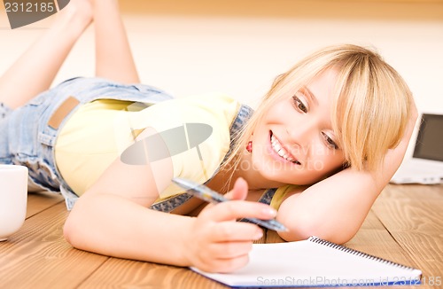 Image of teenage girl with notebook and pen