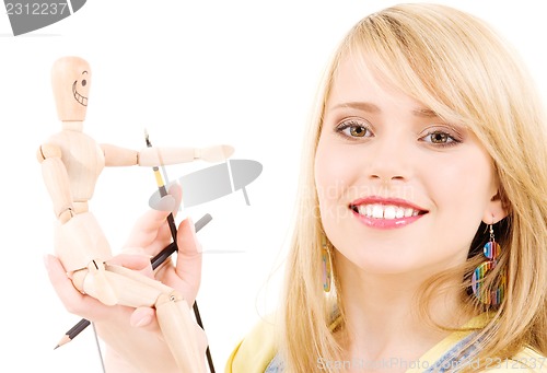 Image of happy teenage girl with wooden model dummy