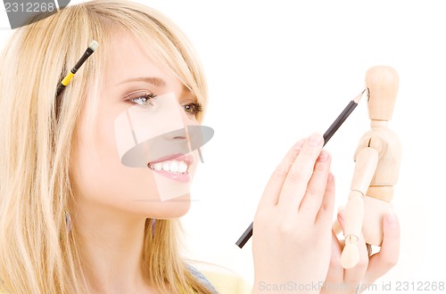 Image of happy teenage girl with wooden model dummy