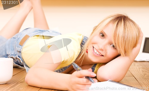 Image of teenage girl with notebook and pen