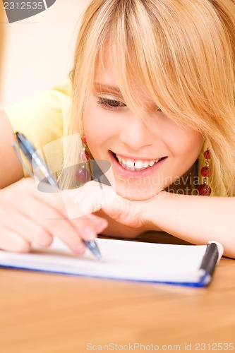 Image of teenage girl with notebook and pen