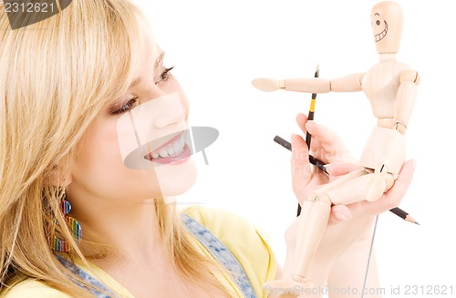 Image of happy teenage girl with wooden model dummy