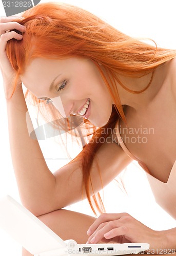 Image of happy redhead woman with laptop computer