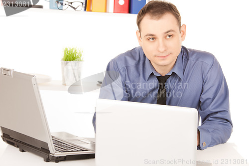 Image of businessman with laptop computer in office