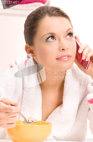 Image of eating woman with cell phone