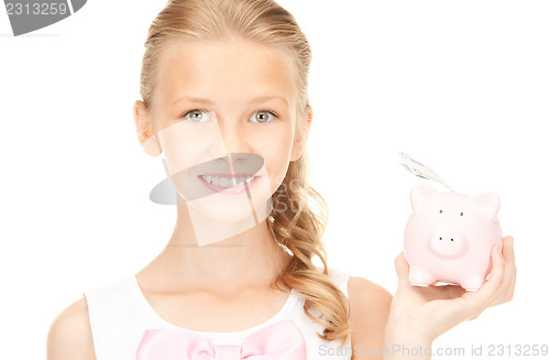 Image of lovely teenage girl with piggy bank and money