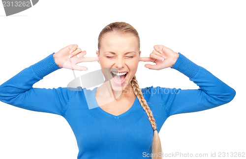 Image of smiling woman with fingers in ears