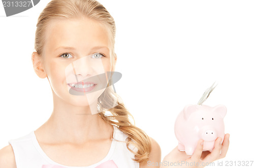 Image of lovely teenage girl with piggy bank and money