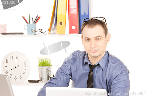 Image of businessman with laptop computer in office