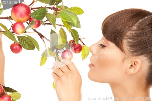 Image of happy woman with apple twig