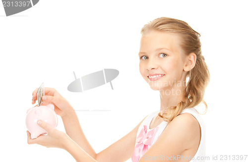 Image of lovely teenage girl with piggy bank and money