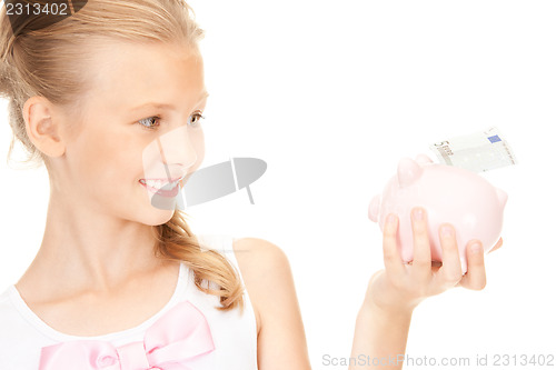 Image of lovely teenage girl with piggy bank and money