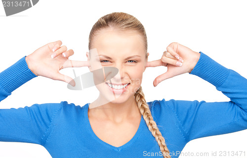 Image of smiling woman with fingers in ears