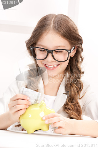 Image of little girl with piggy bank and money