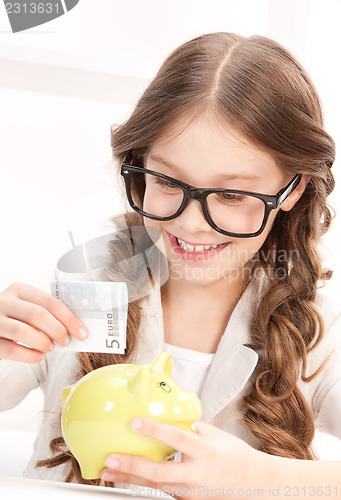 Image of little girl with piggy bank and money