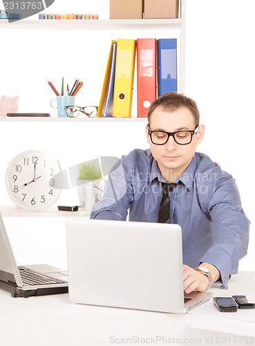 Image of businessman with laptop computer in office