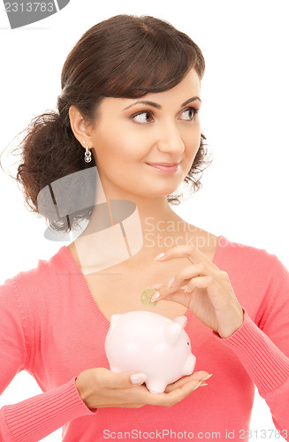 Image of lovely woman with piggy bank and money