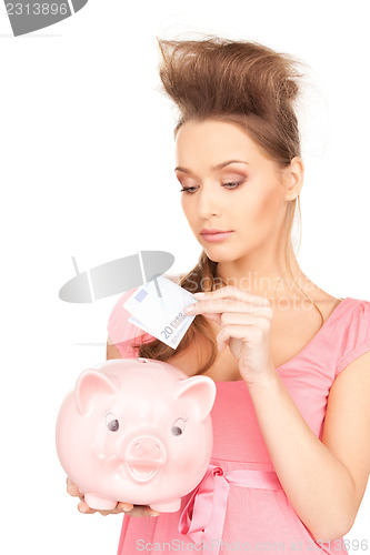 Image of lovely woman with piggy bank and money