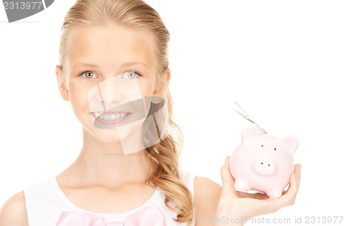 Image of lovely teenage girl with piggy bank and money