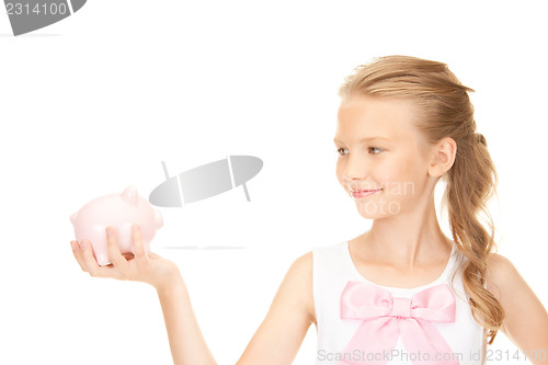 Image of lovely teenage girl with piggy bank