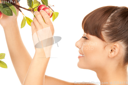 Image of happy woman with apple twig