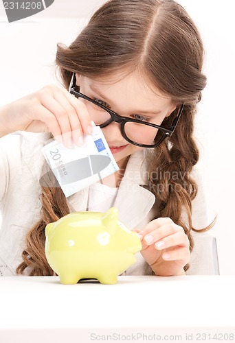 Image of little girl with piggy bank and money