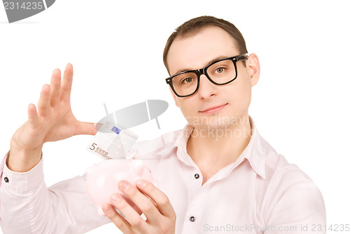Image of businessman with piggy bank and money