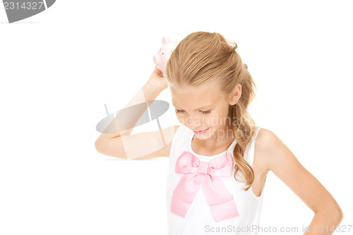 Image of lovely teenage girl with piggy bank