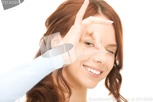 Image of lovely woman looking through hole from fingers