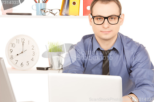 Image of businessman with laptop computer in office