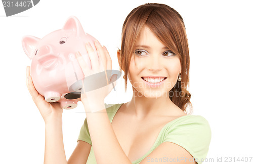 Image of lovely teenage girl with piggy bank