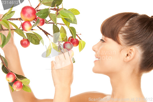 Image of happy woman with apple twig