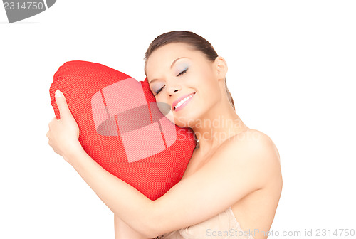 Image of woman with red heart-shaped pillow over white 