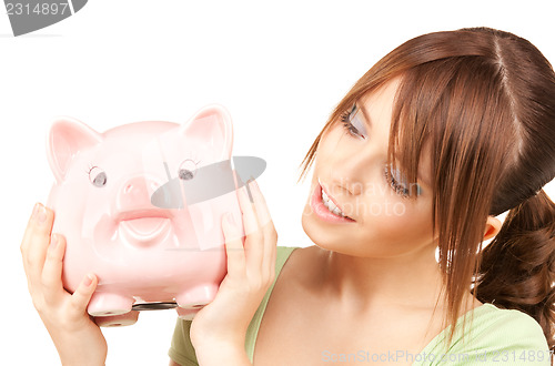 Image of lovely teenage girl with piggy bank