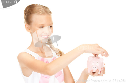 Image of lovely teenage girl with piggy bank and money